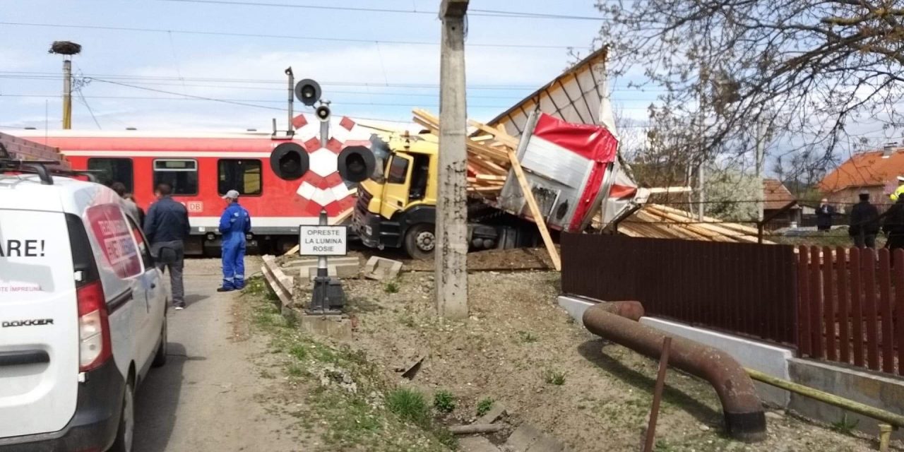 Accident feroviar la trecerea de cale ferată de pe drumul Rușului! Un TIR care transporta lemne a fost lovit din plin de un tren personal. Două persoane din tren, rănite